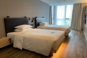 A hotel room with two beds, a nightstand, a lamp, and a window with curtains. - Moxy Shanghai Hongqiao Necc (Shanghai)