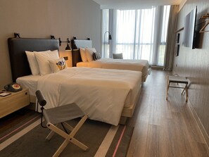 A hotel room with two beds, a desk, a chair, a telephone, and a television. - Moxy Shanghai Hongqiao Necc (Shanghai)