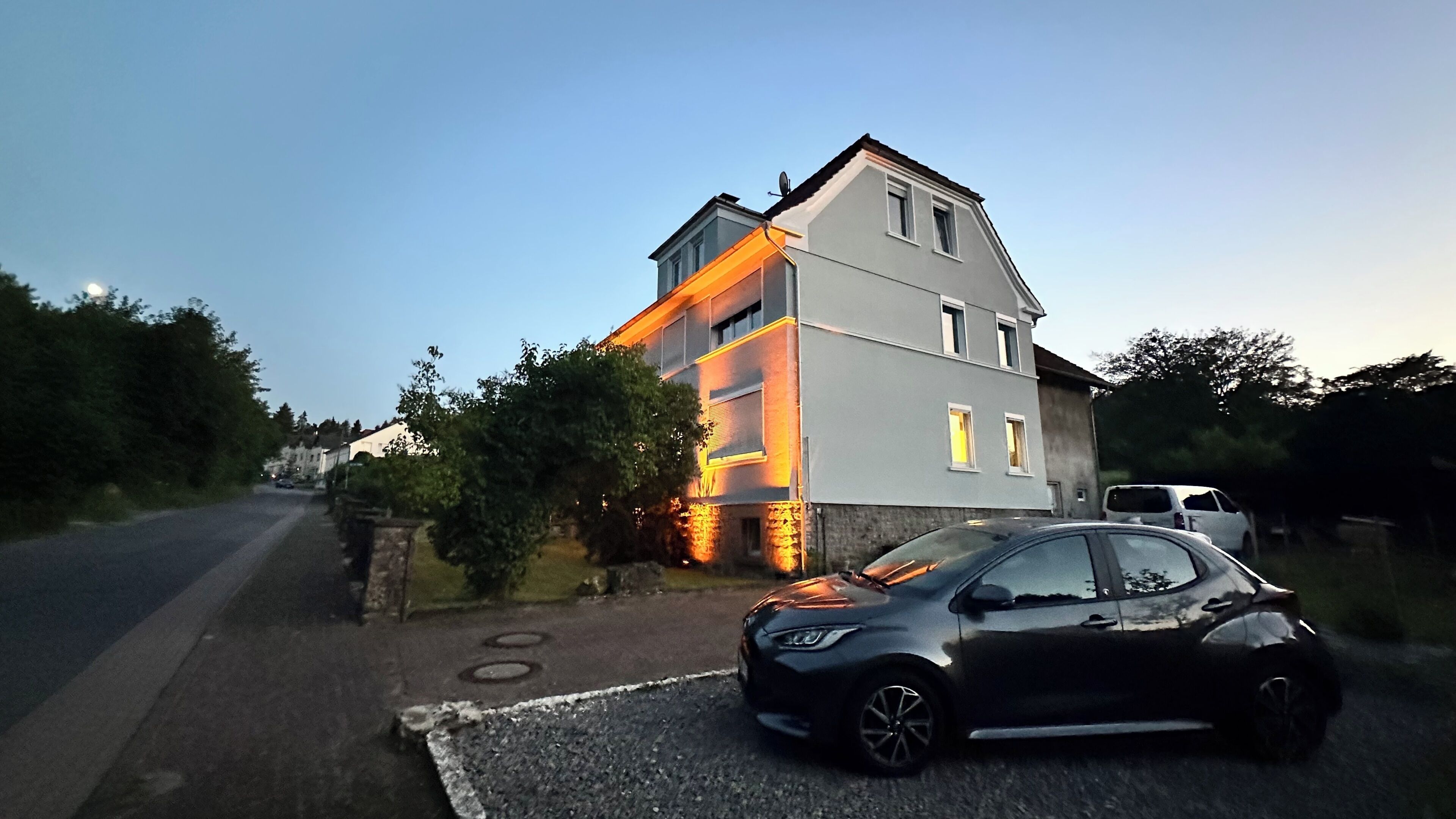 Ein zweistöckiges Haus mit einem geparkten Auto davor.