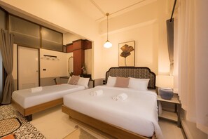 Ein Hotelzimmer mit zwei Betten, einem Nachttisch mit Lampe, einem Spiegel und einem gemusterten Teppich.