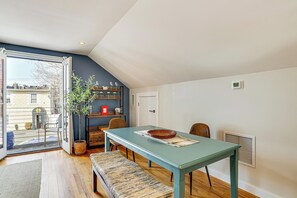 Un coin repas avec une table, un banc et une plante en pot.