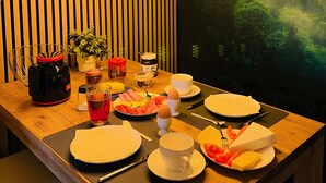 Een eettafel met borden, bestek en verschillende soorten eten.