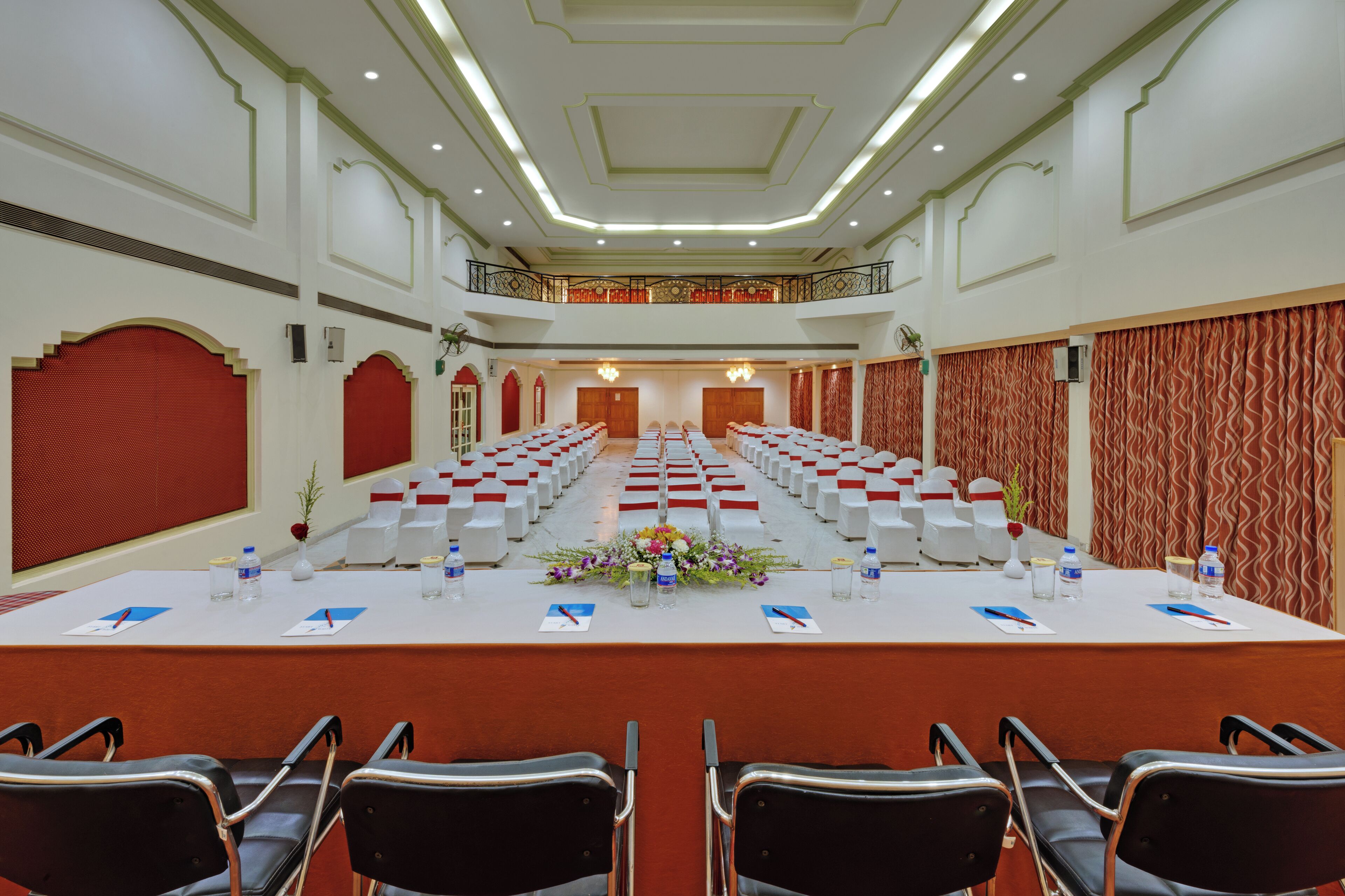 Un salón de conferencias con una larga mesa, sillas y un balcón.