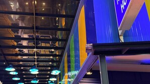 The lobby area of the Blue Neptune Hotel with a modern design, including a bar area visible through the glass doors. - Blue Neptuna Hotel Patong (Patong)