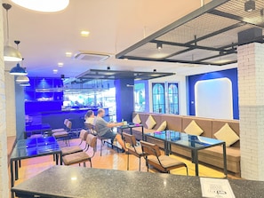 Ein Restaurant mit Sitzgelegenheiten, einer Bar und Blick auf die Straße.