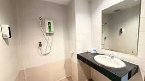 Ein modernes Badezimmer mit einem weißen Waschbecken, einem Spiegel und einer Handbrause.