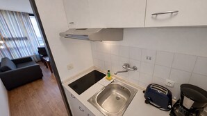 Eine kleine Küche mit Spüle, Toaster und Kaffeemaschine.