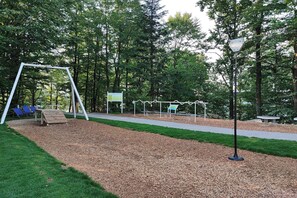 A park with a swing set, benches, and a paved path. - Studio Rainer mit Pool und Sauna (Freyung)