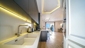 Uma cozinha moderna com duas pias, uma área de refeições com vista e um espaço de estar com varanda.
