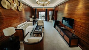 Un salon moderne comprenant un canapé, une table basse, un téléviseur et des panneaux muraux décoratifs.