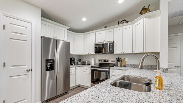 A kitchen with white cabinets, stainless steel appliances, a granite countertop, and a sink. - Dunnellon Escape w/ Yard: 8 Mi to Rainbow River (Dunnellon)