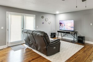A living room with a reclining chair, a television, and speakers.