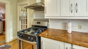 A kitchen with a gas stove, white cabinets, and a wooden countertop. - Little Rock Gem: Historic Home w/ Deck + Yard! (Little Rock)