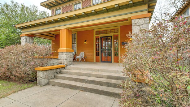 A multi-story building with a porch, stone steps, and a chair outside. - Little Rock Gem: Historic Home w/ Deck + Yard! (Little Rock)