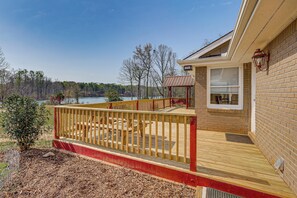 A deck with a railing, a covered seating area, and a view of a lake. - Waterfront Home w/ Views on Bear Creek Reservoir! (Statham)
