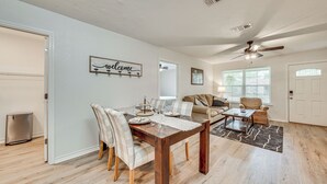 Un comedor con una mesa de madera, sillas y un cartel que dice 'welcome'.
