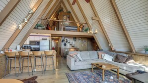 Um espaço de estar tipo loft com cozinha, sala de jantar e área de estar.