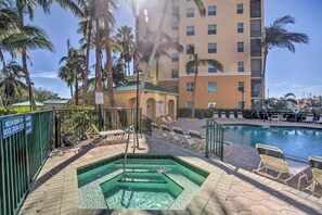 A hotel pool area with a hot tub, lounge chairs, and palm trees. - Sunsets & Sails! Waterfront Punta Gorda Condo (Punta Gorda)