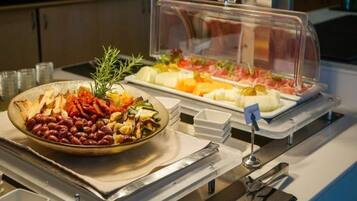 A buffet with various food items, including beans, vegetables, and meats, displayed in clear containers.