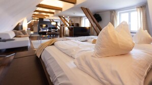Moderni hotellihuone, jossa on suuri sänky, sohva, työpöytä ja televisio.