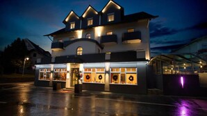 Ein mehrstöckiges Hotel mit einer markanten Eingangsparte, Balkonen und einem überdachten Außenbereich.