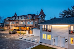 A two-story building with a traditional architectural style, featuring a prominent tower and multiple windows. - Garni Hotel Royal Crown (Subotica)