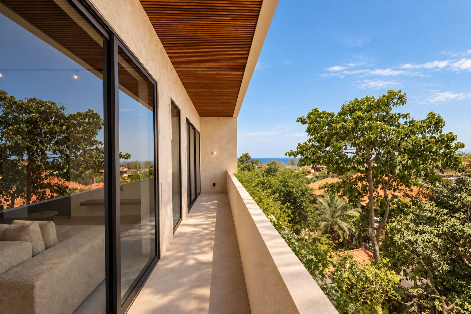 A modern balcony with a view of a lush landscape and distant buildings.