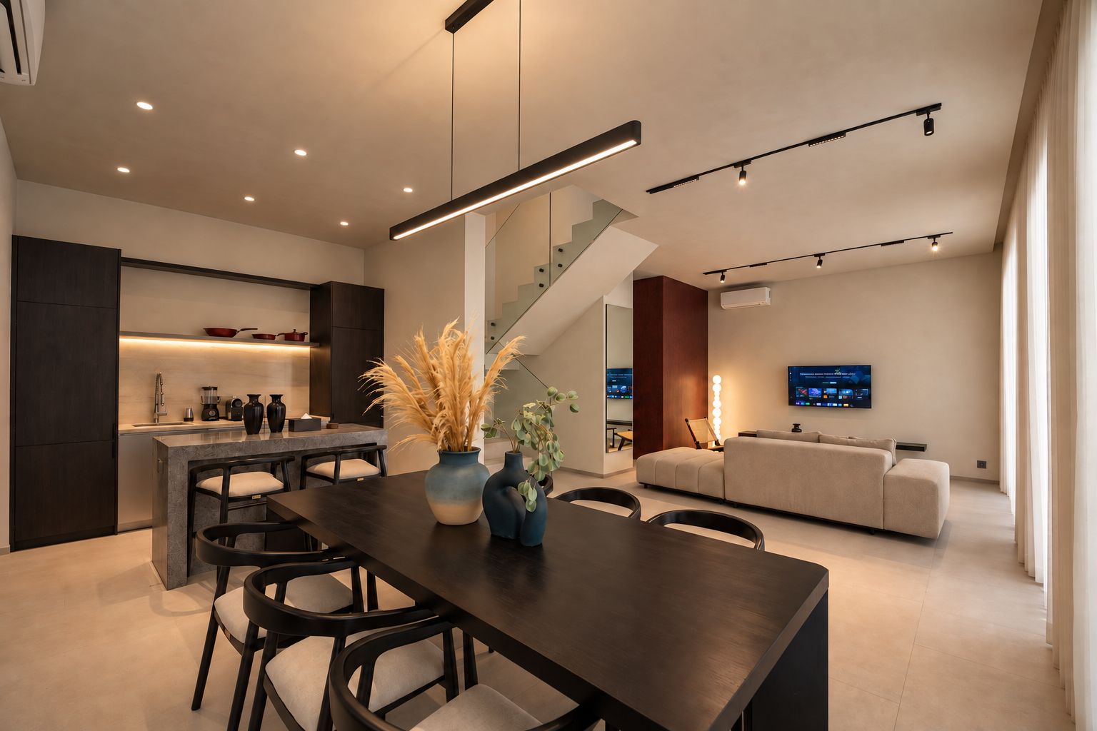 Un interior moderno con comedor, cocina, escalera y sala de estar.
