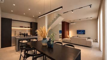 Un interior moderno con comedor, cocina, escalera y sala de estar.