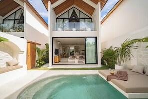 A modern two-story house with a swimming pool, outdoor seating, and a balcony with plants. - Villa Enola Uluwatu (Uluwatu)