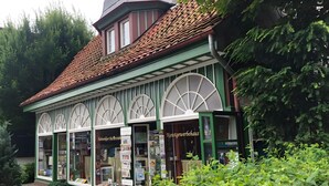 A building with a red-tiled roof, green trim, and large arched windows.