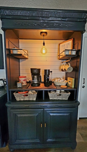 A kitchen with a coffee station, including a coffee maker, cups, and a sign that says 'I like big cups.' - Ambervine  (Lowell)