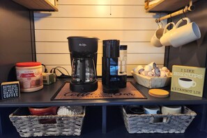Eine Kaffeestation mit Kaffeemaschine, Kaffeemühle und einem Schild mit dem Aufdruck: 'I like big cups & I cannot lie.'