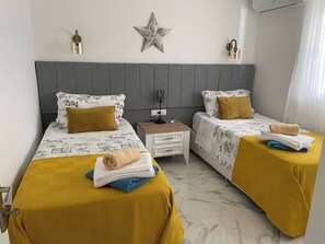 A hotel room with two beds, a star decoration on the wall, and a nightstand with a lamp. - Sylvana Apartment- a Little Piece of Kalkan Heaven (Kaş)