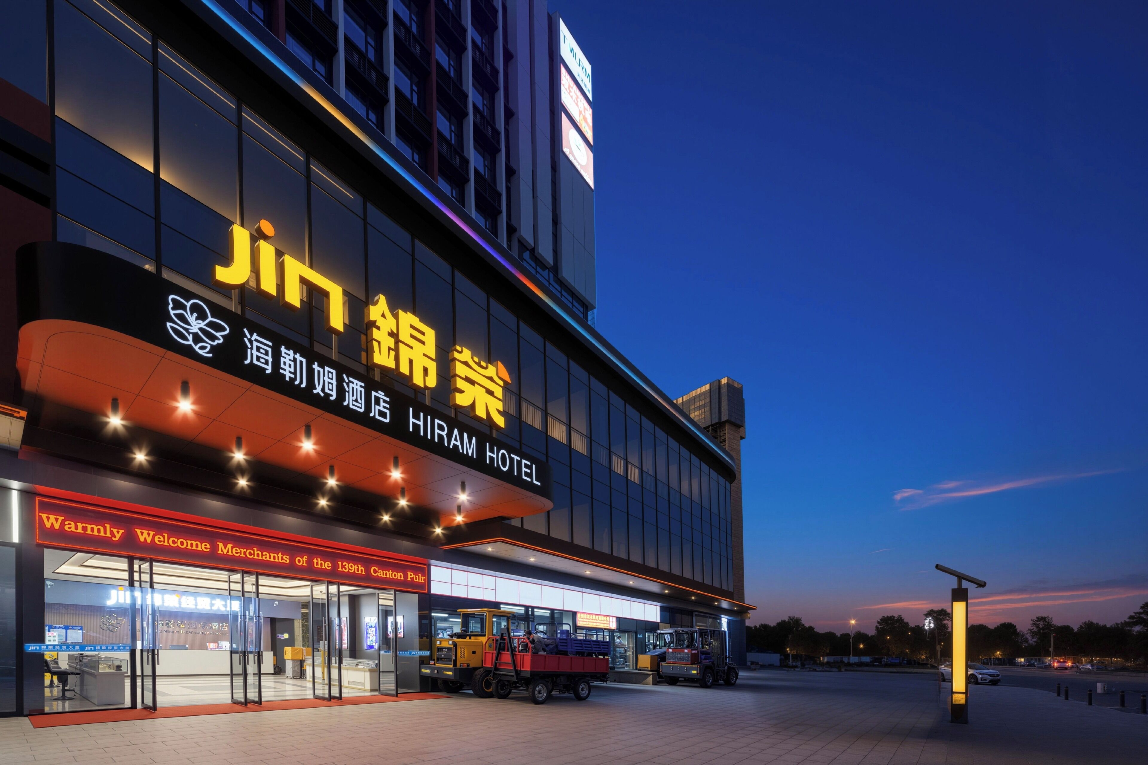 A hotel with a prominent sign, a large entrance, and a parking area.