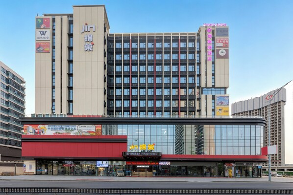 A multi-story hotel with a prominent Hiram Hotel sign, large windows, and a red awning. - Guangzhou Hiram International Hotel - Free shuttle bus to Guangda Trade City and Xiaobei Market (Guangzhou)