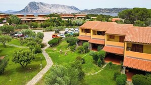 Una zona residenziale con diversi edifici di due piani, un vialetto lastricato e auto parcheggiate.