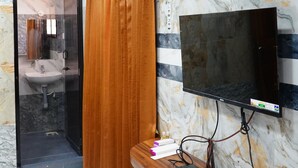 A bathroom with a sink, mirror, and shower. - SUMI WHITE HOUSE (Thanjavur)