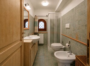 A bathroom with a shower, two sinks, a toilet, and a bidet. - Porto San Paolo - Sea View House with Garden (Porto San Paolo)