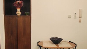 A room with a wooden cabinet, a small table with a bowl, two chairs, a wall-mounted phone, and a light switch. - The Best offer! 2-bedroom apartment in Vracar with AC for relaxing stays (Beograd)