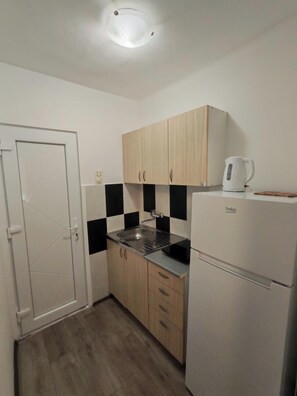 A compact kitchen with a sink, cabinets, a kettle, and a refrigerator. - The Best offer! 2-bedroom apartment in Vracar with AC for relaxing stays (Beograd)
