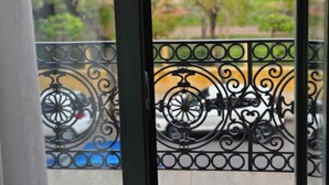 A balcony with a metal railing and a view of trees and a park. - Apon City Residence (Chania)
