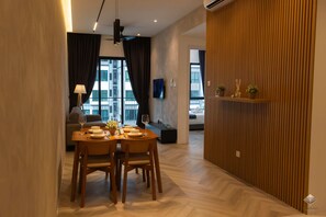 A modern dining area with a wooden table, chairs, and a television on the wall.