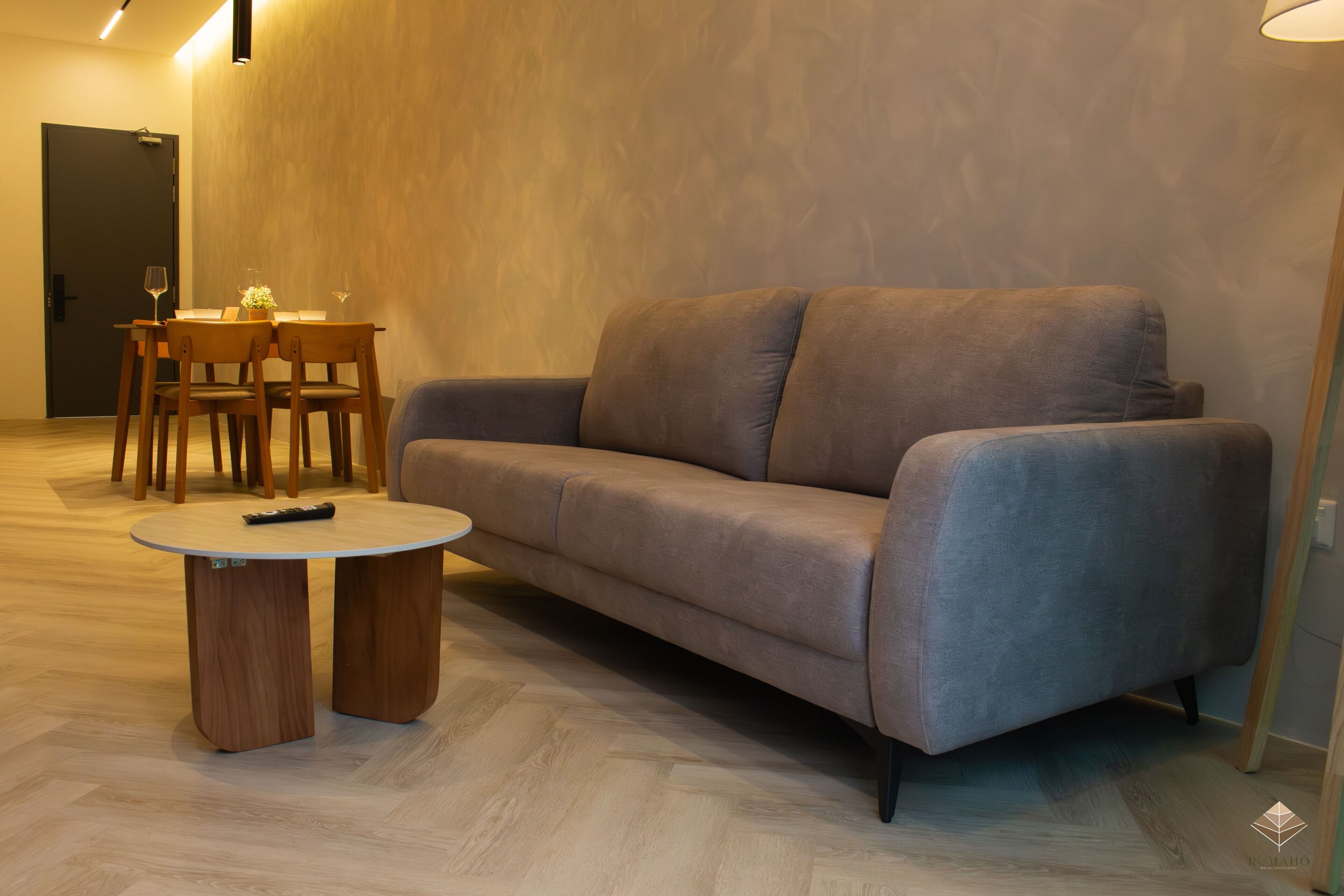 Uma sala de estar moderna com um sofá, uma mesa de jantar com cadeiras e uma pequena mesa de centro.