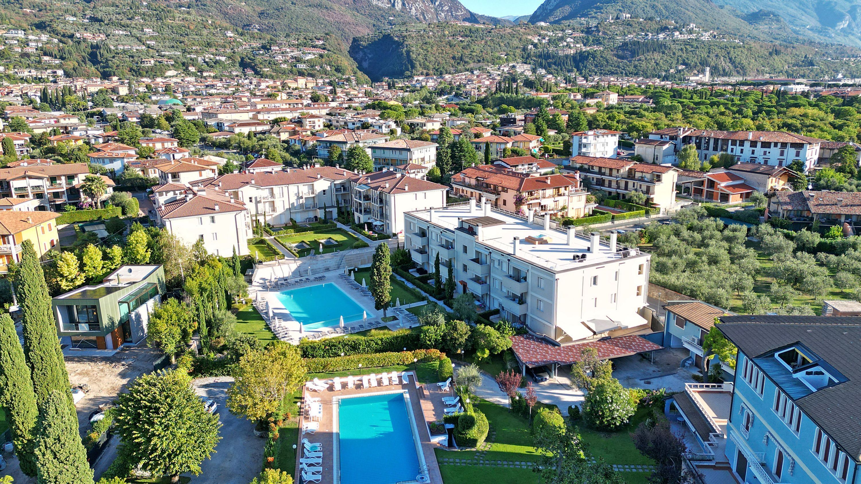 A resort with multiple buildings, a swimming pool, and a mountainous backdrop.