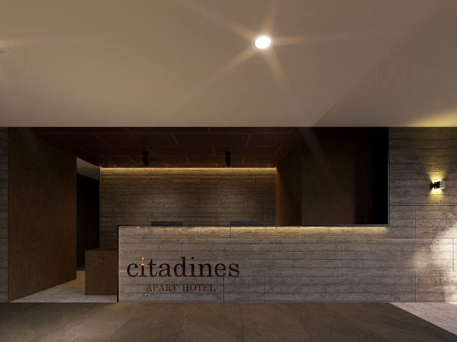 Een receptiebalie met een bord waarop 'citadines apart hotel' staat, in een moderne hal met houten lambrisering en inbouwverlichting.