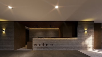 A reception desk with a sign reading 'citadines apart hotel' in a modern lobby with wooden paneling and recessed lighting.