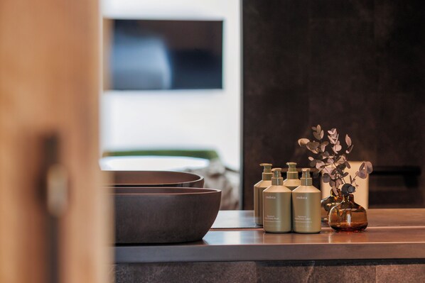 A bathroom counter with toiletries and a vase of dried flowers. - Citadines Elizabeth Street Pier Hobart (Hobart)