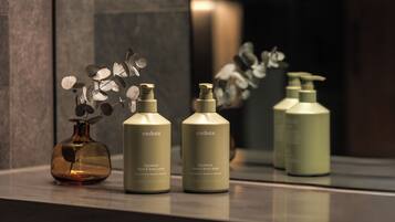 Three bottles of Endota Signature Hand & Body Lotion and Hand & Body Wash on a reflective surface.