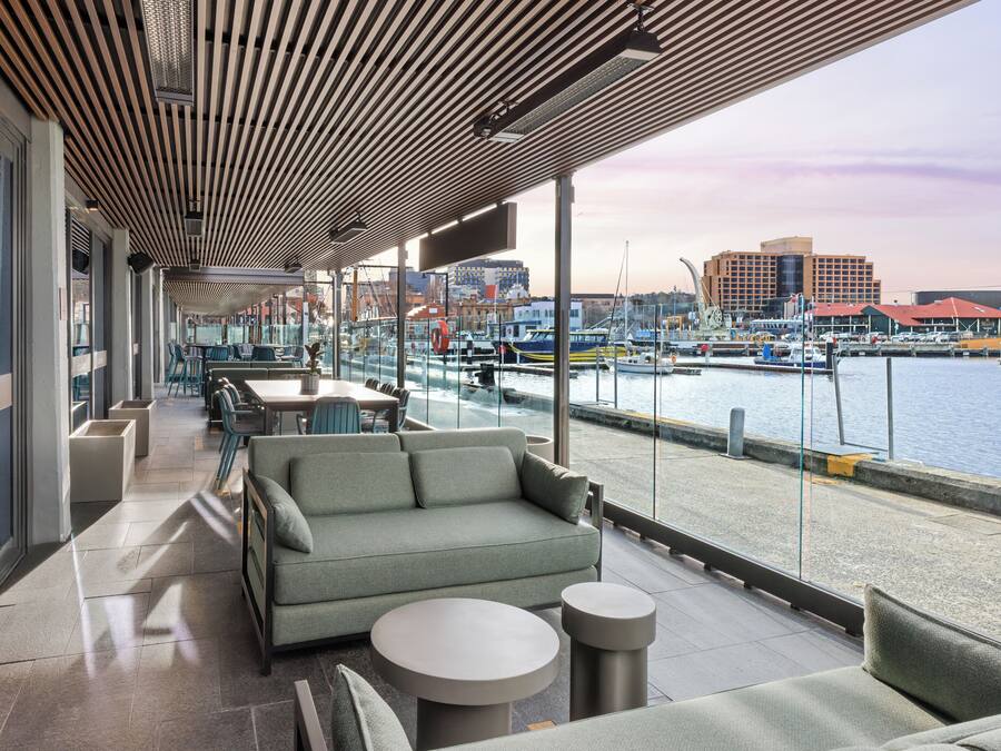 An outdoor seating area with a view of the marina and cityscape.